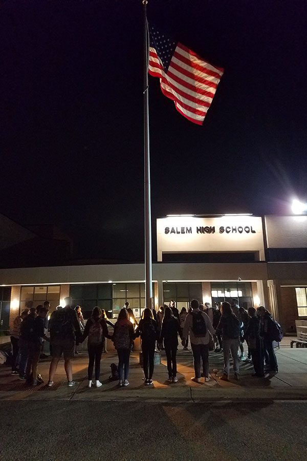 30-40 Christian P-CEP students hold hands and pray around Salem flag pole.