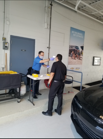 Owner Scott LaRiche takes the temperature of employee Bert Saucido.