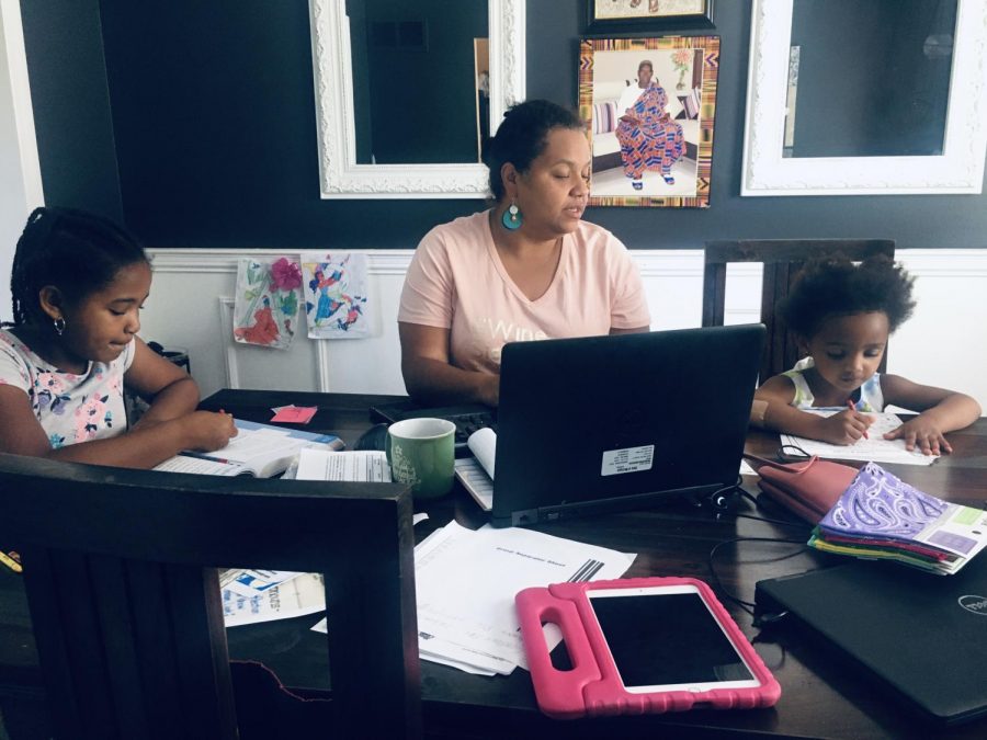 Nicole Denson-Sogbaka helps her kids with their assignments as she works from home.