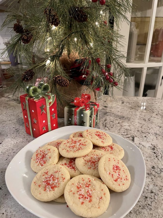 A plate of sugar cookie delights from Allrecipes.com rests near a festive display. 
