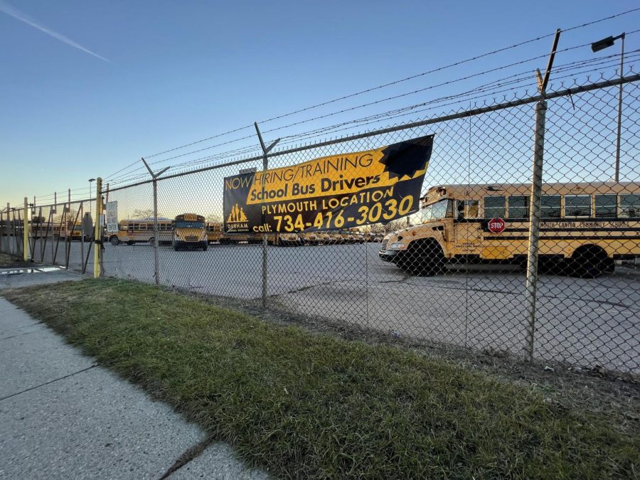 A school bus lot fence advertises hiring and training opportunities at Durham School Services in Plymouth, Michigan, amidst a lack of school bus drivers Dec. 4.