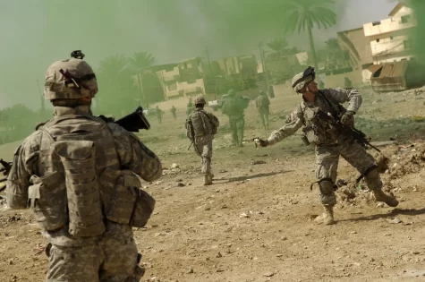 U.S. Army Sgt. Bill Stachler throws a smoke grenade to mask his teams movements during a joint operation with the Iraqi police in Baqubah, Iraq, March 31, 2007. The purpose of the operation is to clear houses and palm groves near the Diyala River of any insurgent forces. Stachler is with the 5th Battalion, 20th Infantry Regiment. 