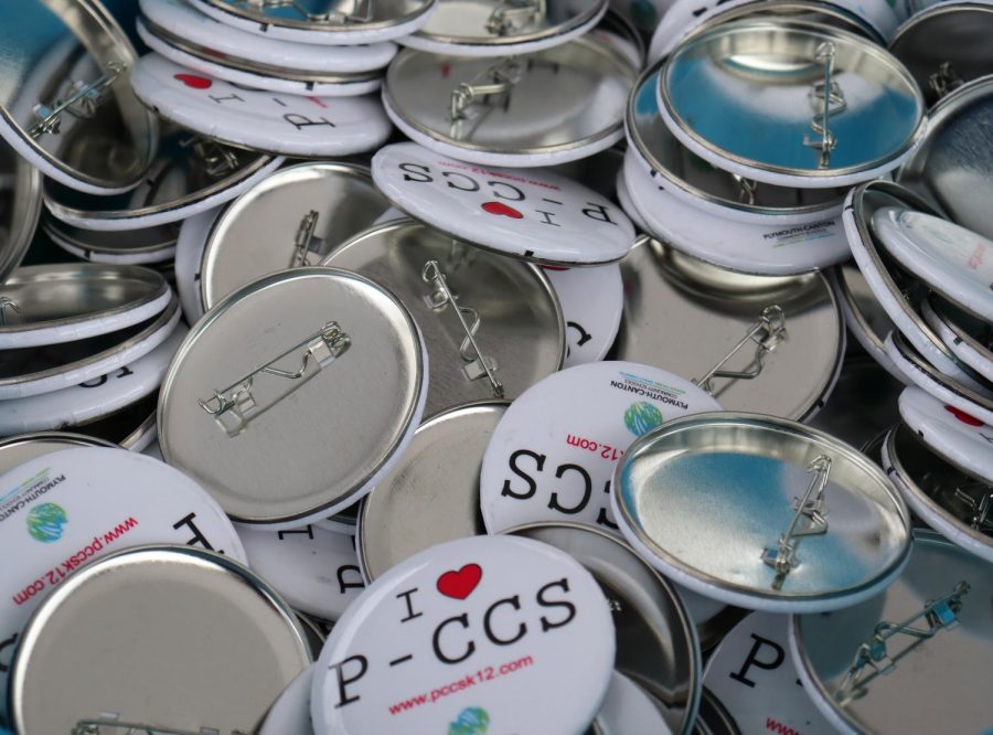 Buttons promoting the Plymouth-Canton Community School  district are available for grabs inside of the P-CCS information booth, set up in Kellogg Park during the Mental Health and Wellness Fair. April 30, 2022. 