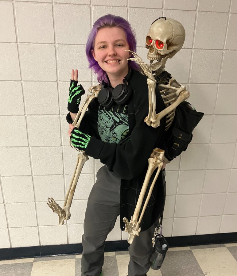 A+plastic+skeleton+carries+books+and+school+supplies+while+Lily+Bradow%2C+Salem+senior%2C+carries+the+skeleton.+October+13%2C+2022.