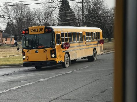  Plymouth-Canton Community Schools bus drops off students on Haggerty Road with its stop-arms and flashing lights activated. December 21, 2022. 