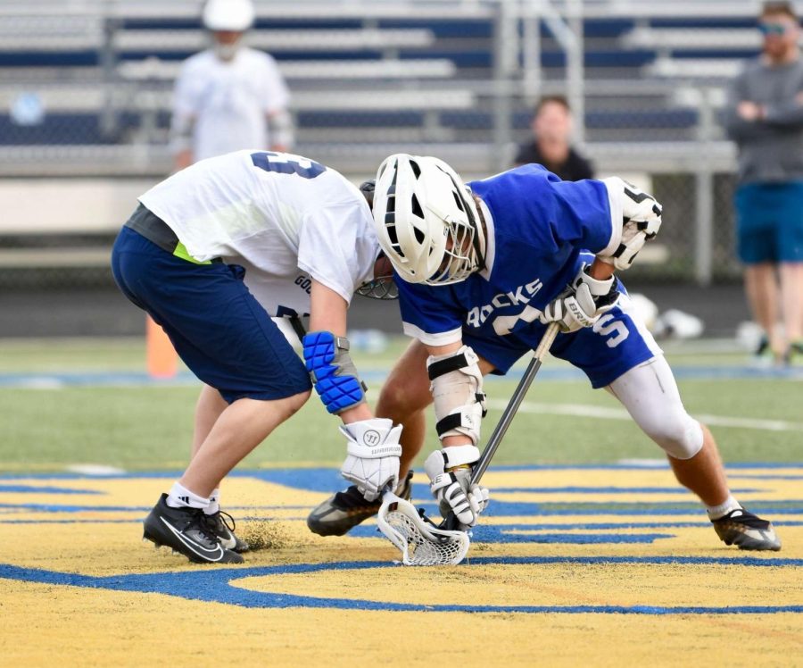 Salem Sophomore, Aidan Moore, fights for the ball during a faceoff. 