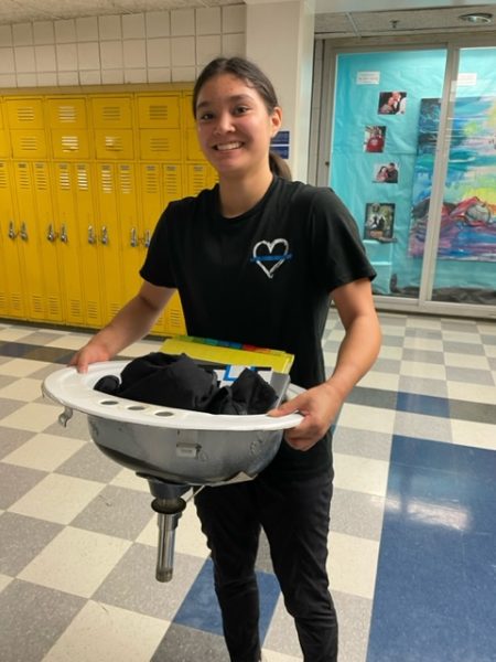 Alexis Muir, Canton freshman, carries her supplies with a bathroom sink. Sept. 20, 2023. Donna Gatzke

