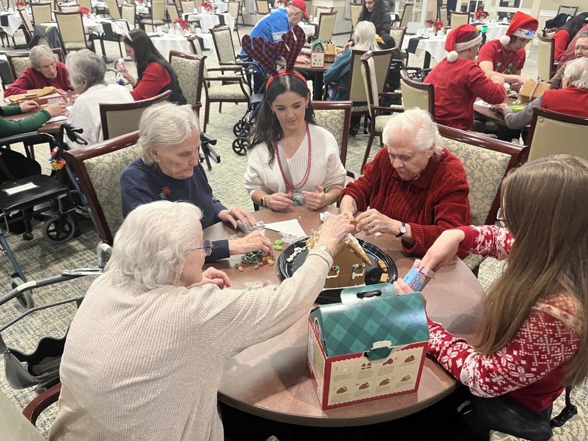 Giving Heart club members work with Independence Village
 residents to create their gingerbread house, which was later awarded 
first place. December 16, 2023. 