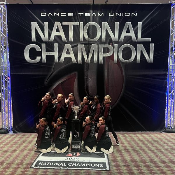 The P-CEP Varsity Dance Team embraces together with their trophy. Top row, left to right: Cadence Toby, Salem sophomore; Grace Bec, Plymouth freshman; Albrie Whitlow, Canton junior; Sienna Ruel, Plymouth junior; and Taylor Wade, Canton sophomore. Bottom row, left to right: Avery Nimmerguth, Salem sophomore; Emilia Testa, Canton senior; Presley Albrecht, Salem senior; Chloe Carn, Salem senior; and Kendall Best, Salem senior. February 11, 2024. 
