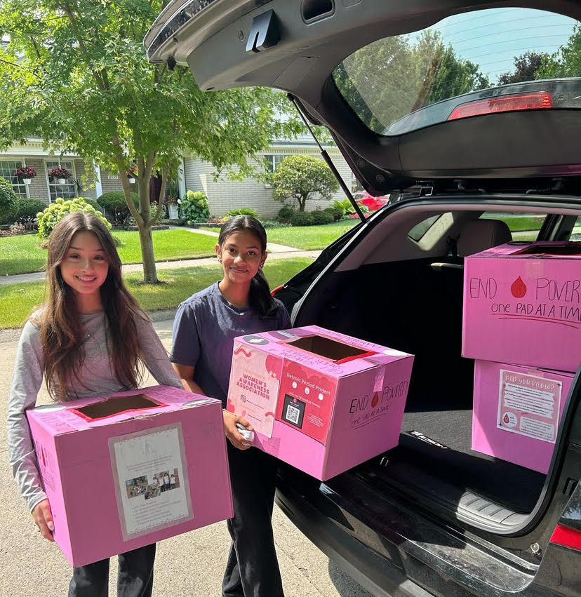 Salem senior Diya Sompura (left)  and Canton senior Kimaya Samak (right) carry boxes created by the WAA to hold menstrual product donations. Aug. 30, 2024.