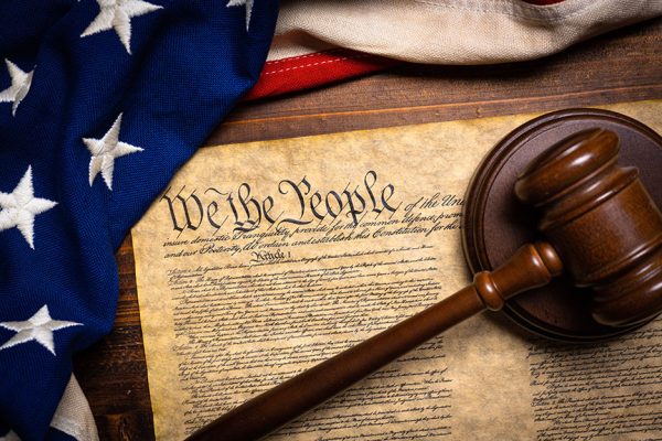 "The American constitution, a wooden gavel and an American flag," © Michael Flippo - stock.adobe.com, licensed 26 November 2024.