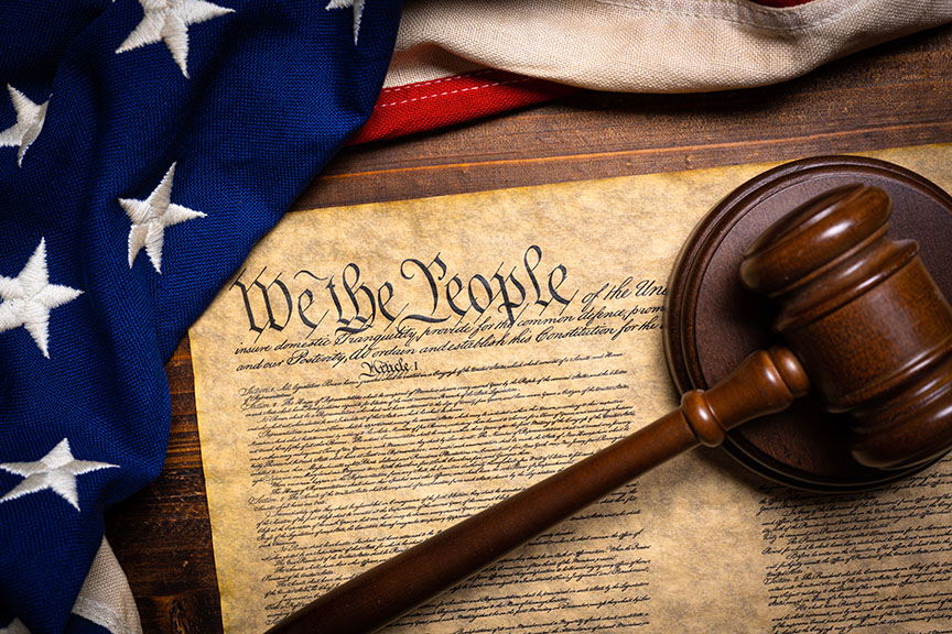 "The American constitution, a wooden gavel and an American flag," © Michael Flippo - stock.adobe.com, licensed 26 Nov. 2024.