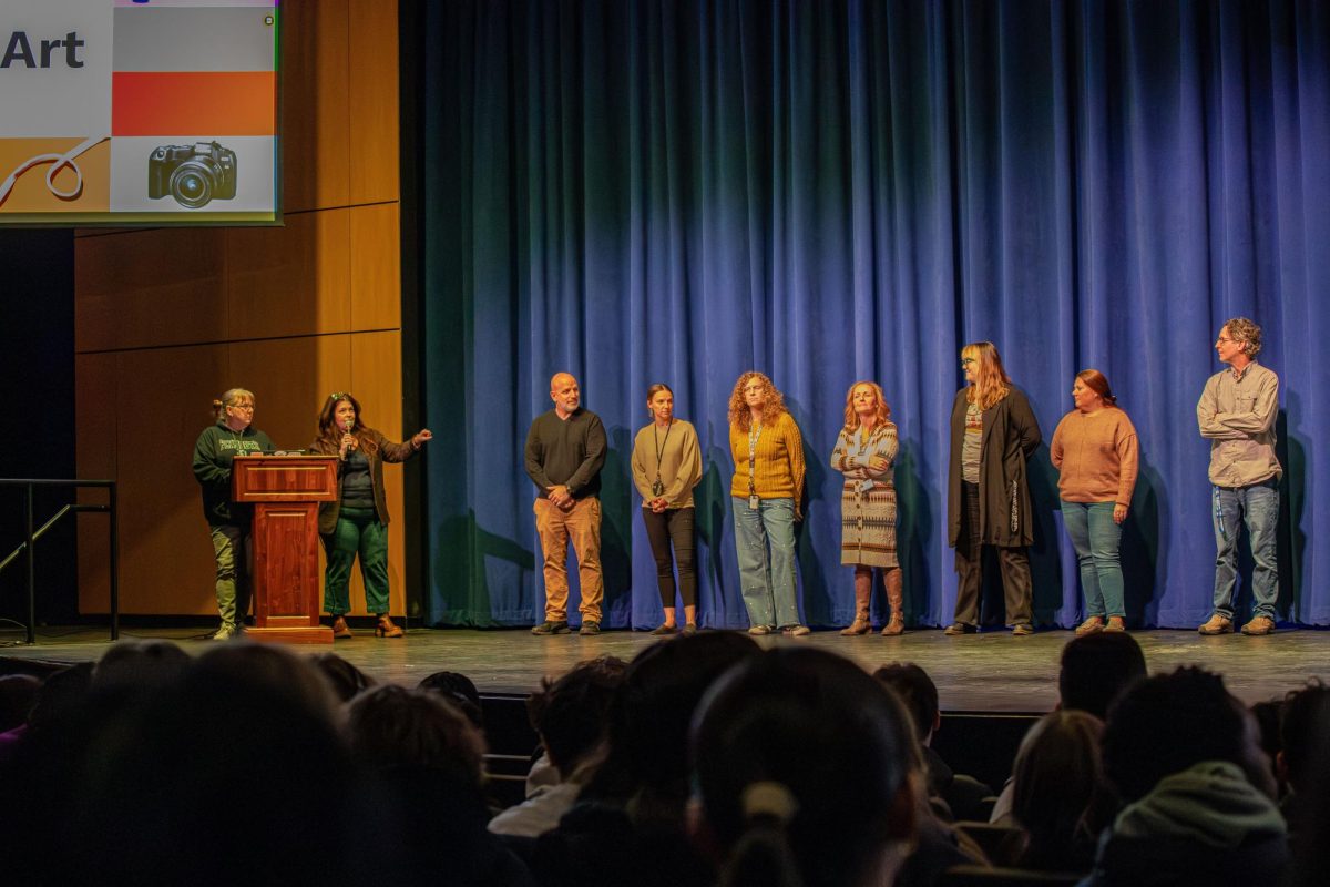 Clevell Koon, Plymouth art teacher, and Keli Osborne, Salem art teacher, introduce teachers of the art department at the Collage Concert: (from left to right) Salem teacher Craig Linderman; Plymouth teachers Jeannine Sutherland and Lindsey Pignatiello; Salem teachers Ann Espinoza, Lauren Nalepa, Nellie Maltby and Barrie Lincourt, Feb. 5, 2025.