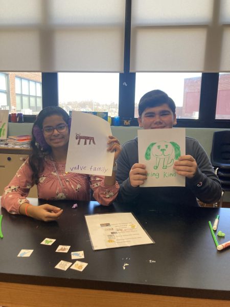 Julia Jose (left) and Jacob Roman (right) select one value and draw an animal that represents that value in the Art Room.  March 21, 2025.