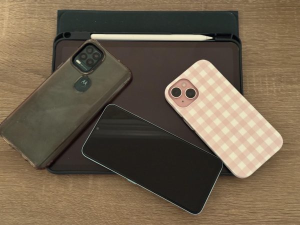Smartphones and tablets rest on a desk. While House Bill 4141 mandates a ban during instructional time, P-CCS administrators will still have the final say on whether high schoolers can use phones during passing periods and lunch. Jan. 15, 2026. 