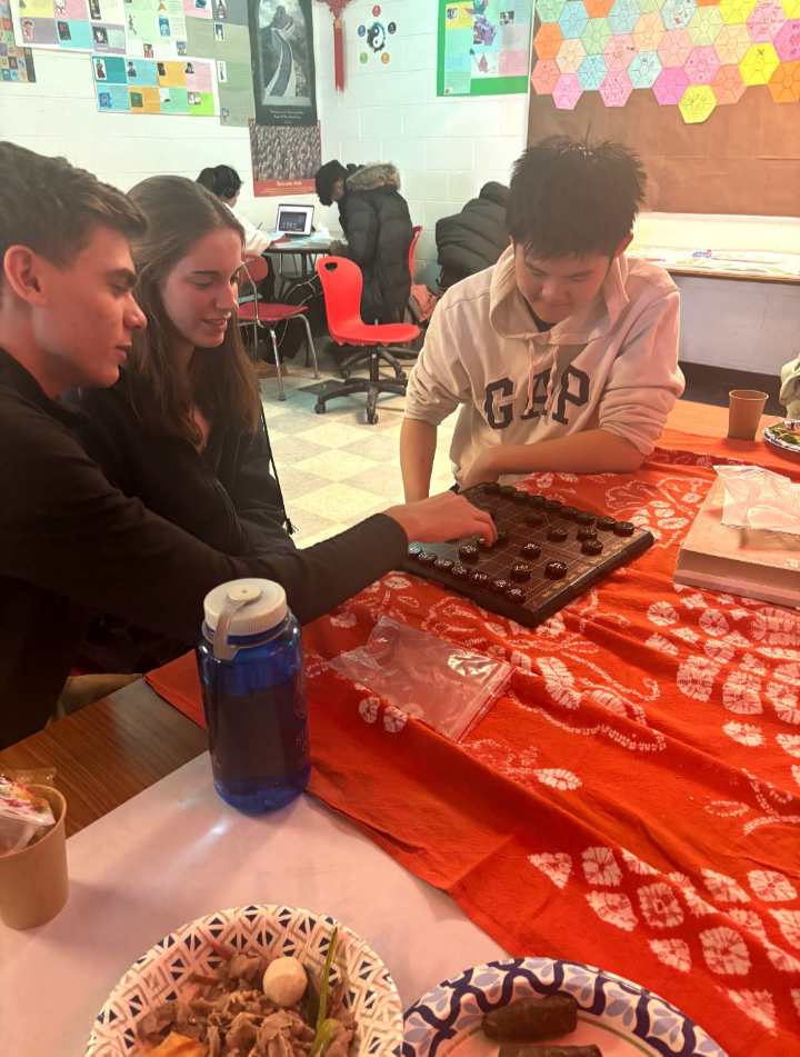 Plymouth senior Lucus LaPointe (left), Plymouth senior Caroline LaPointe (middle), and Canton junior Jayme Fang (right) play Xiàngqí (象棋: Chinese chess) during the Chinese New Year celebration in the classroom of Canton Mandarin teacher, Li Zhang. February 4, 2026. 