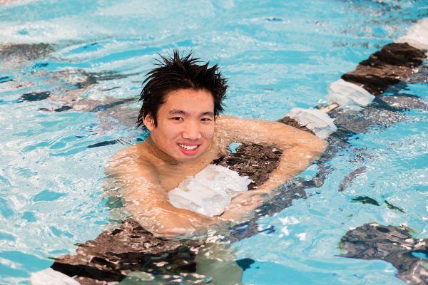Anthony Chen holding onto the lane rope in the water during a Plymouth senior photo shoot. Nov. 25, 2025.